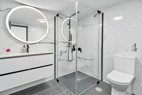 Un baño con ducha, inodoro y espejo. en Villa Infinite, en Salobreña