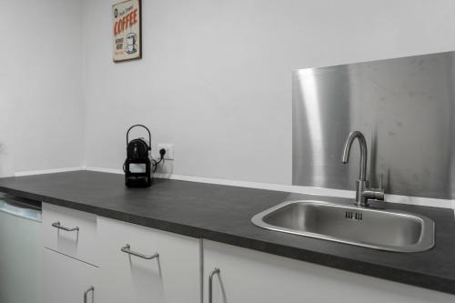 a kitchen with a stainless steel sink and white cabinets at Studio Flat - Lungara 44A in Rome