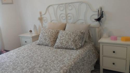 a bed with a white headboard and pillows on it at Casa dess in Hospitalet de Llobregat