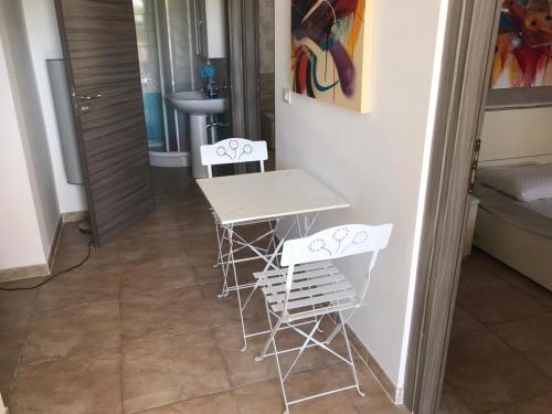 a table and chairs in a room with a sink at Villa Tellina Mare Luna in Granelli