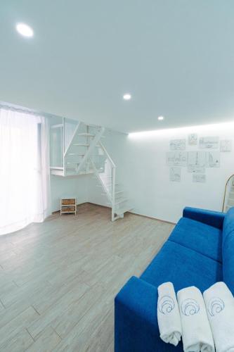 a living room with a blue couch and a staircase at Casa Celeste in Monopoli