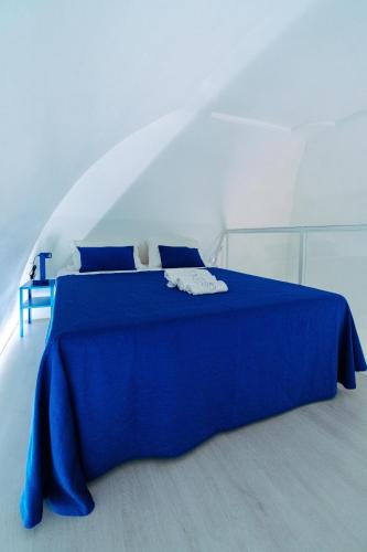 un letto blu con una coperta blu sopra di Casa Celeste a Monopoli