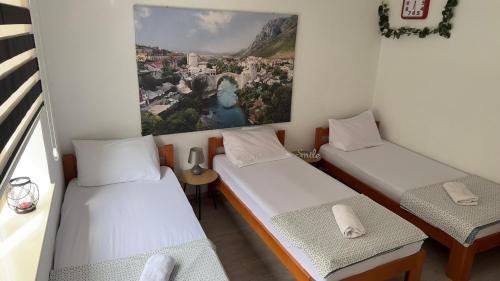 duas camas num quarto com uma fotografia na parede em Villa Zigana em Mostar