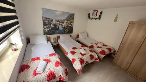 two beds in a room with red and white comforters at Villa Zigana in Mostar