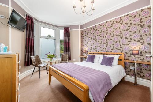 a bedroom with a bed and a tv in it at Thornbank House Offering Breakfast and with Free Off Site Health Club in Windermere