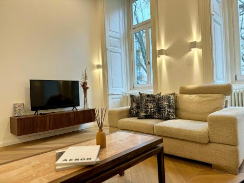 a living room with a couch and a tv at Maison Frank in Budapest