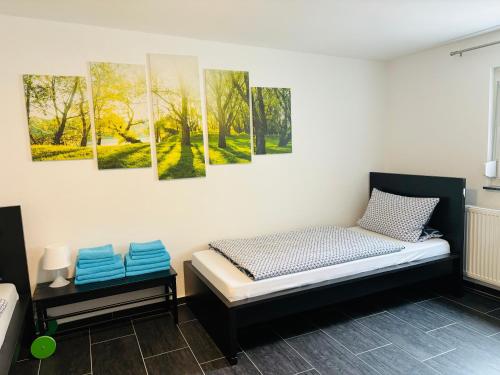 Zimmer mit einem Bett und Gemälden an der Wand in der Unterkunft Ferienwohnung Seeblick in Allersberg