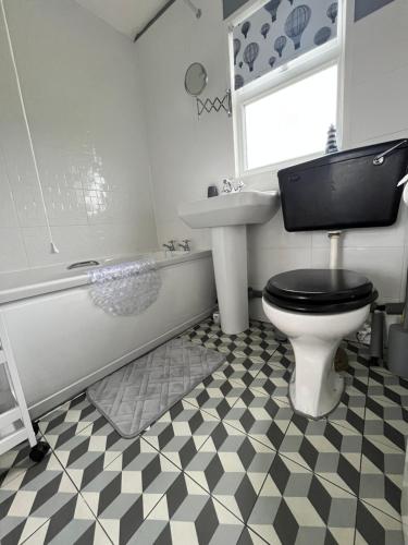 a bathroom with a toilet and a sink and a tub at California Beach Chalet in Great Yarmouth