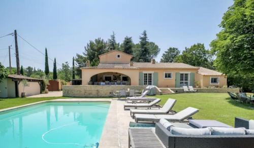 une piscine avec des chaises longues et une maison dans l'établissement Magnifique villa avec piscine village à pied, à Éguilles