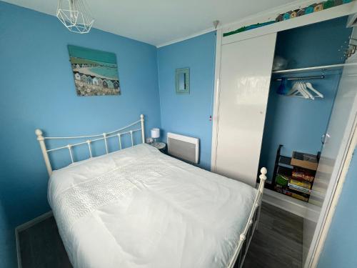 a bedroom with a bed with blue walls at California Beach Chalet in Great Yarmouth