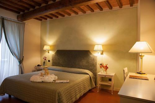 a bedroom with a bed with two stuffed animals on it at Borgo Sant'ippolito Country Hotel in Ginestra