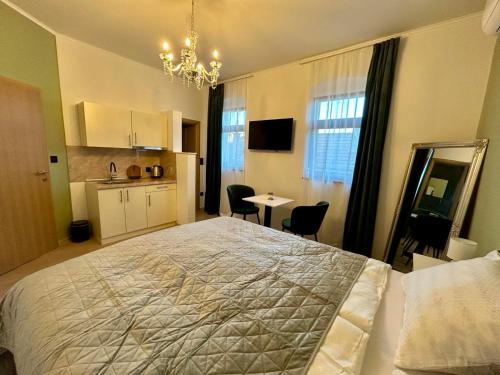 a bedroom with a large bed and a small kitchen at AD BASANTE in Bosanski Šamac