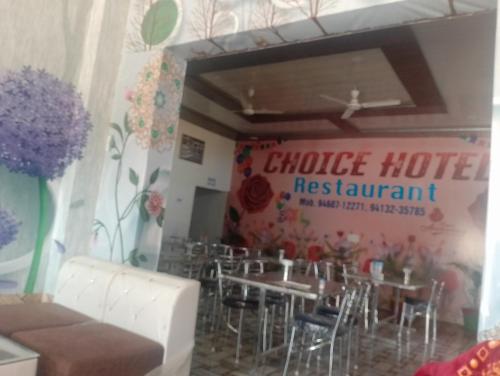 a restaurant with tables and chairs and a sign that reads choice hotel restaurant at CHOICE HOTEL AND RESTAURANT CAFE in Hanumāngarh