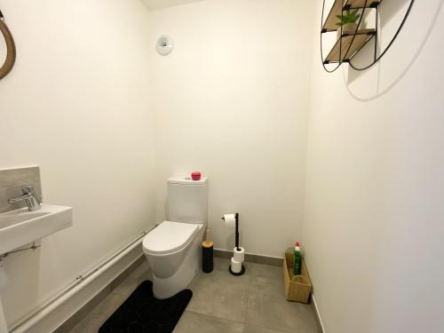 une salle de bain blanche avec des toilettes et un lavabo dans l'établissement The Modern Chic Haven, La Défense (16'), Parking, à Bezons