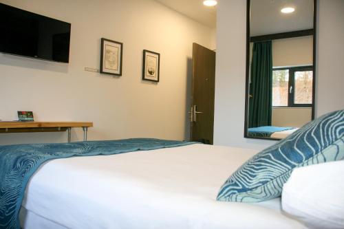 a bedroom with a bed and a tv on the wall at The Base Camp Hotel, Nevis Range in Fort William