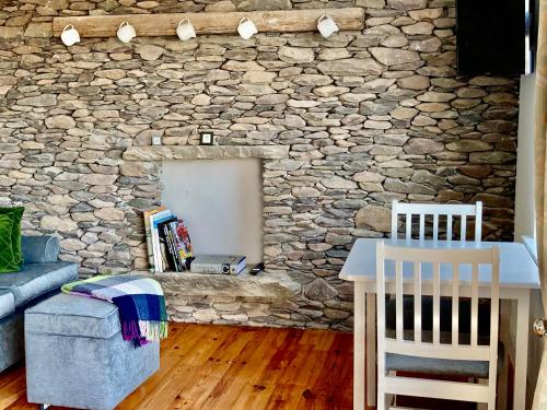 a living room with a stone wall at Cille Apartments, Ballyferriter village in Ballyferriter