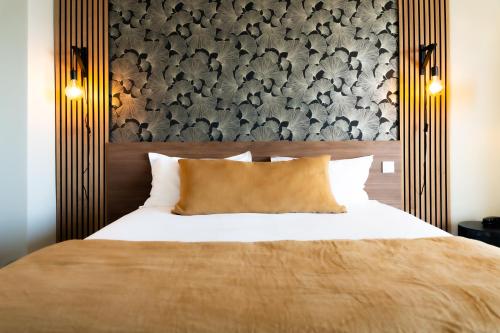 a bedroom with a bed with a large headboard at Hôtel Mar I Cel & Spa in Canet-en-Roussillon