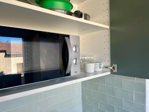 un four micro-ondes installé sur une étagère dans une cuisine dans l'établissement Le Beauséjour, à Montpellier