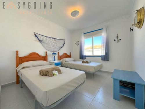 a bedroom with two beds and a blue table at ¡El Pescador - junto al mar! in Santa Pola