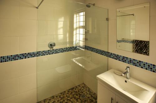 a white bathroom with a sink and a mirror at Top Deck, Langebaan in Langebaan
