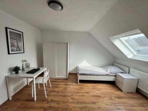 1 dormitorio con escritorio, 1 cama y ventana en Eterna Smart Living en Krefeld