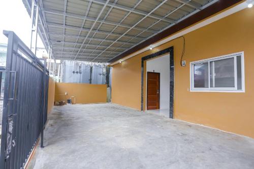 an empty room with a yellow wall and a door at Super OYO 92626 Good Sleep 4 Inn Dcos Syariah in Samarinda