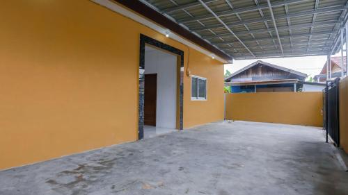 une porte ouverte d'un bâtiment avec un mur jaune dans l'établissement Super OYO 92626 Good Sleep 4 Inn Dcos Syariah, à Samarinda