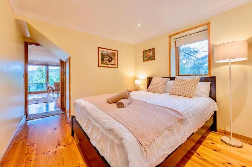 Wonga Park的住宿－Perfect View Retreat in Forest，一间卧室设有一张大床和一个窗户。