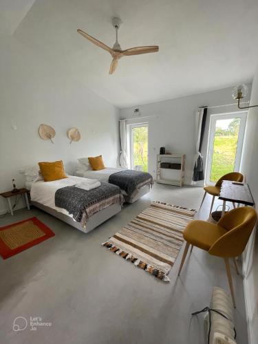 a bedroom with two beds and a ceiling fan at Monte da Urze Aljezur - Agroturismo in Aljezur