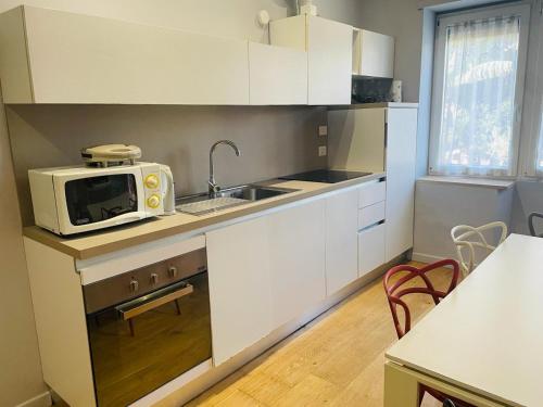 a kitchen with white cabinets and a microwave on a counter at Casa Santarelli in Rome