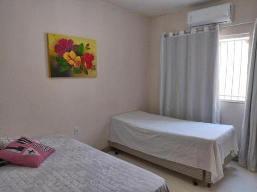 古利利的住宿－Casa de Praia Lado Sul，一间卧室设有两张床,墙上挂着一幅画