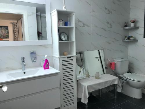 a white bathroom with a sink and a toilet at Panorama superieur in Netanya