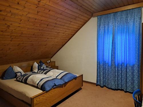 a bedroom with a bed with a blue curtain at Webergütl in Auna di Sopra