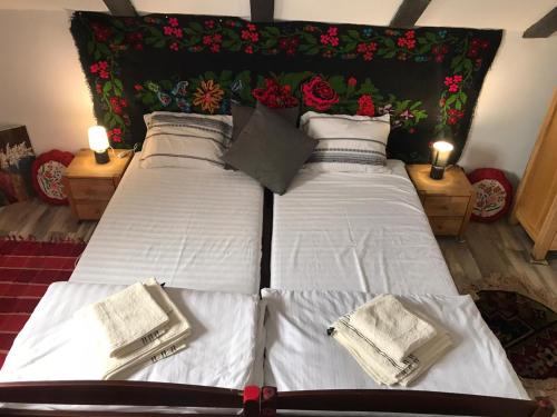1 dormitorio con 2 camas con sábanas blancas y velas en Casa cu piscina Cheile Nerei, en Socolari