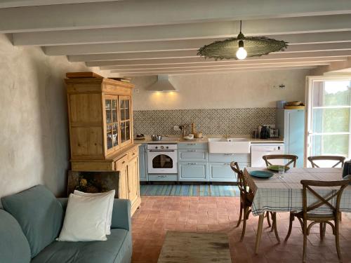 a living room with a table and a kitchen at Quinta Baltazar Casa particular in Vila Nova De Cacela