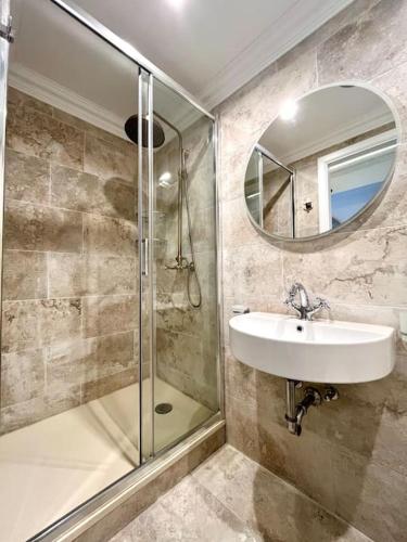 a bathroom with a shower and a sink and a mirror at Seafront Beach House in St.Julians in Sliema