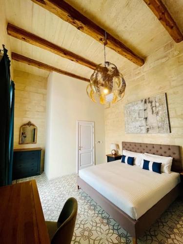 a bedroom with a large bed and a chandelier at Seafront Beach House in St.Julians in Sliema