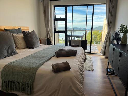 ein Schlafzimmer mit einem großen Bett mit einem großen Fenster in der Unterkunft De View in Knysna