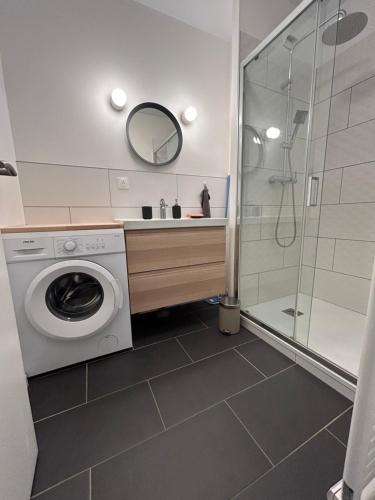 La salle de bains est pourvue d'un lave-linge et d'une douche. dans l'établissement Le patio : Appartement chic 3 chambres au cœur de Pau, à Pau