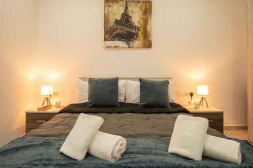 a bedroom with a large bed with two lamps at Modern, Bright & Spacious Apartment near the sea in Marsaskala
