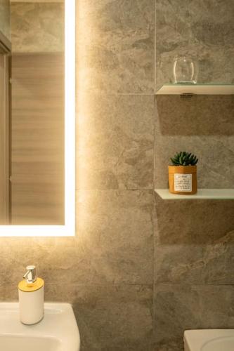 a bathroom with a sink and a toilet and a mirror at Modern, Bright & Spacious Apartment near the sea in Marsaskala
