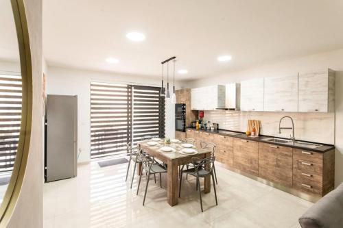 a kitchen with a table and chairs in a room at Modern, Bright & Spacious Apartment near the sea in Marsaskala