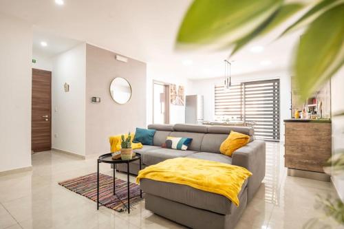 a living room with a couch and a table at Modern, Bright & Spacious Apartment near the sea in Marsaskala