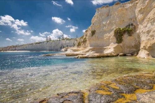 a view of the ocean and a rocky beach at Modern, Bright & Spacious Apartment near the sea in Marsaskala