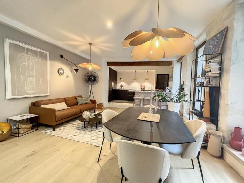 a living room with a table and a couch at Appartement de charme avec cour in Avignon