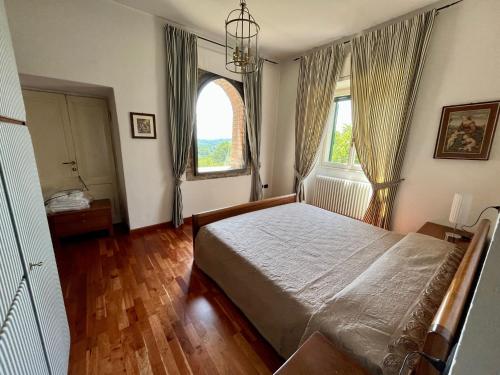 een slaapkamer met een bed en 2 ramen bij Villa Moia in Varese