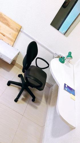 a black chair sitting in a room next to a sink at Tranquilo Bed and Breakfast in Gisenyi