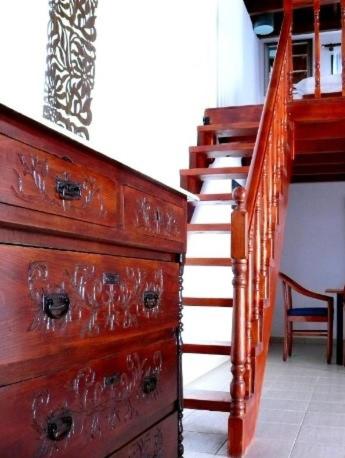 a wooden staircase next to a dresser and a wooden drawer at Villa Rosa in Kattavía