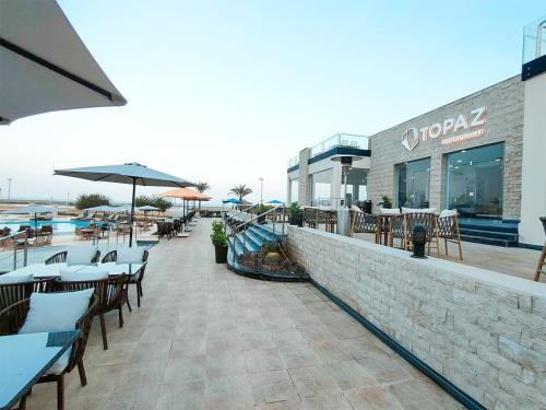 a patio with tables and chairs and a restaurant at Eastern El-Galala Aquapark Ain Sokhna in Ain Sokhna