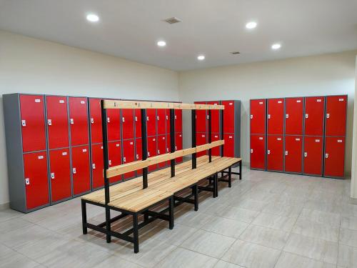 a locker room with red lockers and a wooden bench at Eastern El-Galala Aquapark Ain Sokhna in Ain Sokhna